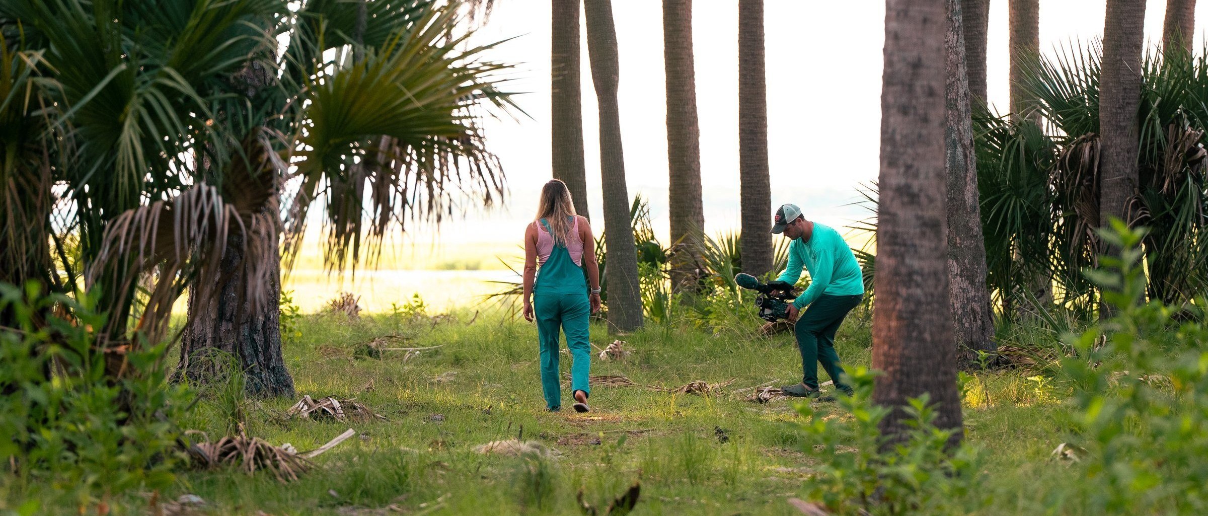 Behind the scenes: crew filming among palm trees